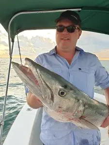 Charter guest displaying impressive barracuda catch during Lower Keys fishing adventure