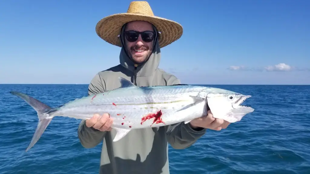 Charter guest proudly displaying caught barracuda during Lower Keys fishing adventure