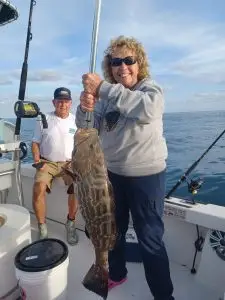 Couple displaying past fish catch during previous Lower Keys charter adventure