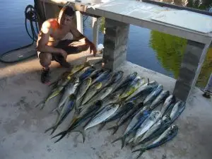 Charter guest proudly displaying catch on Summerland Key dock after Lower Keys fishing adventure