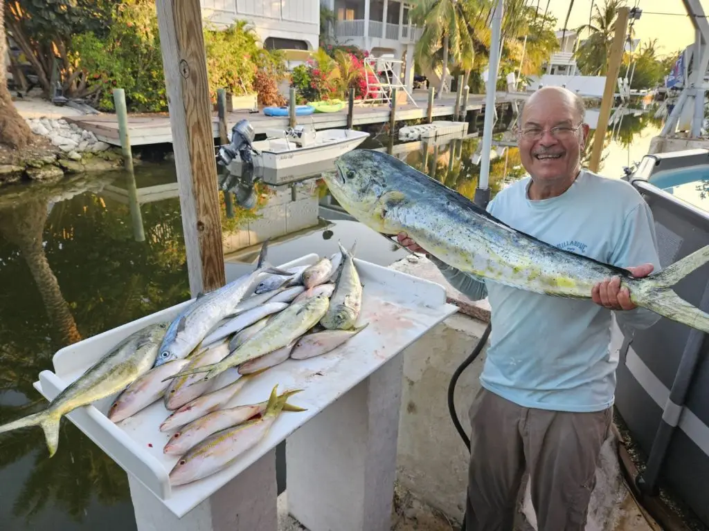Charter guest displaying multiple fish catches on dock during past Lower Keys adventure