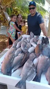 Family displaying their catch on dock from past Lower Keys charter adventure