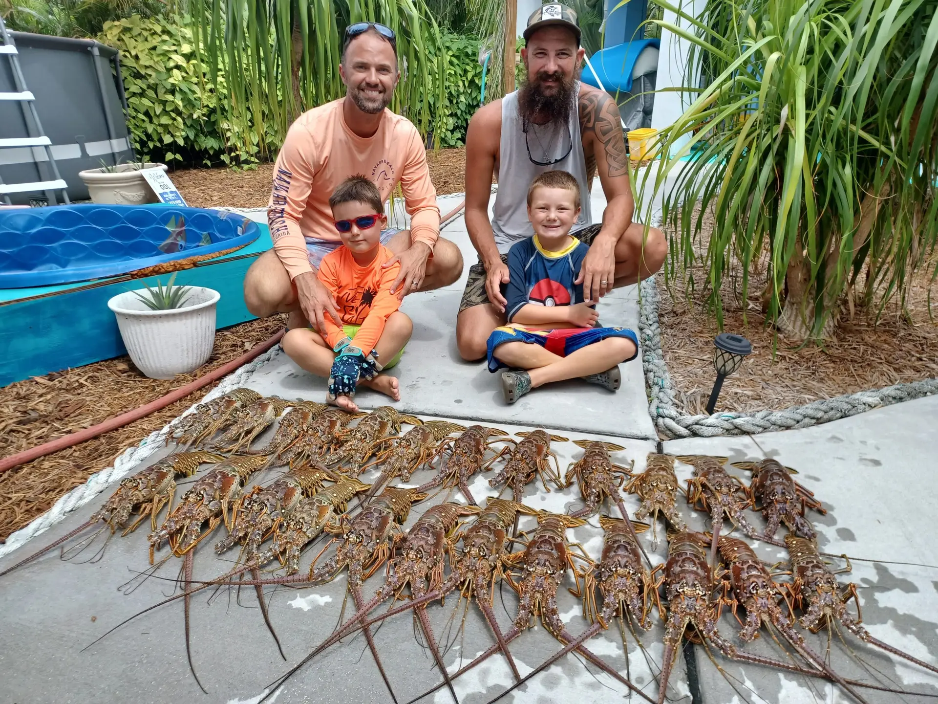 Two fathers and their children proudly displaying lobster catch during Lower Keys family charter adventure