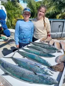 Two children proudly displaying their catch on dock from past Lower Keys charter adventure