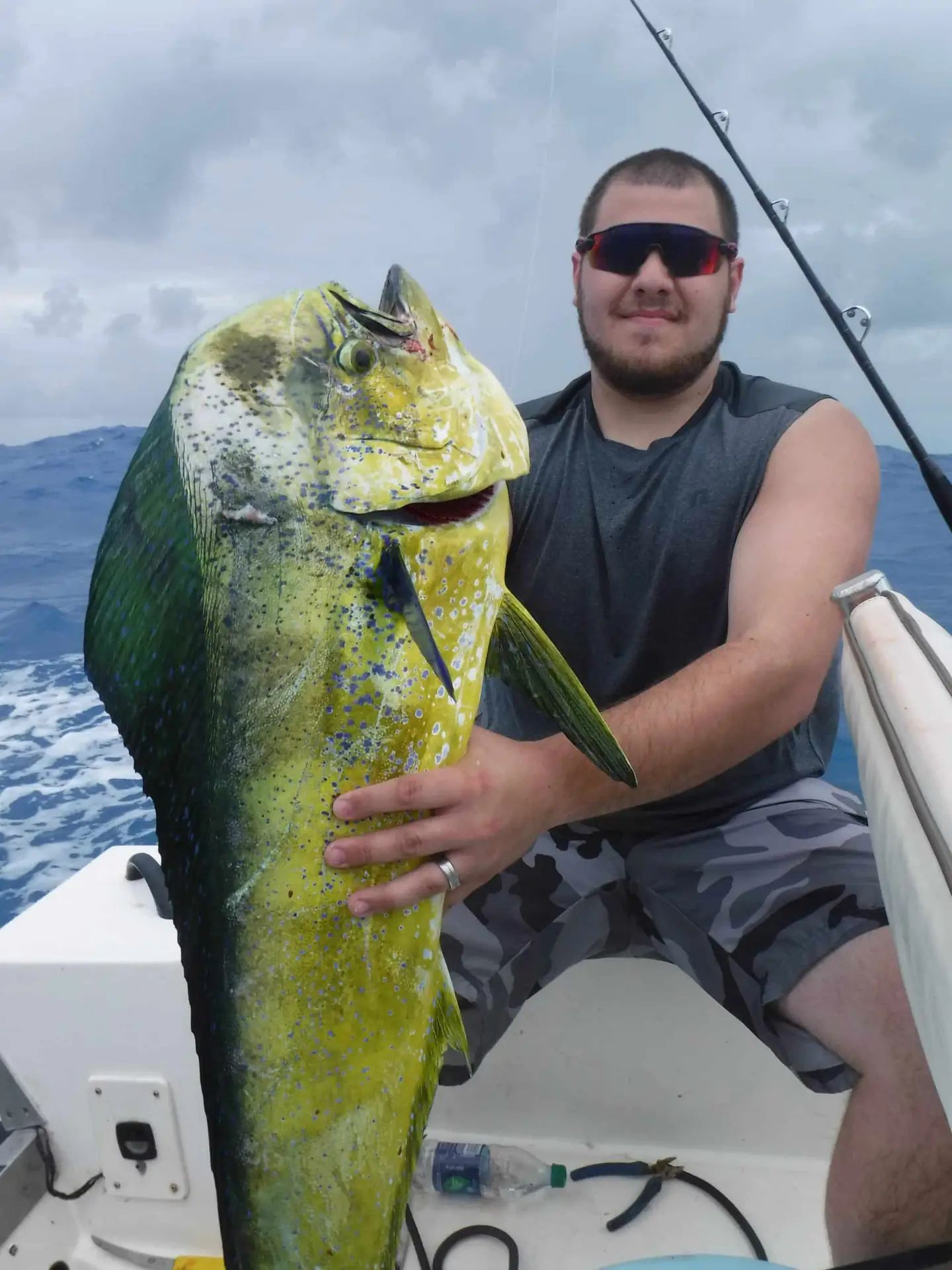 Charter guest proudly displaying fresh mahi mahi catch aboard vessel in Lower Keys waters