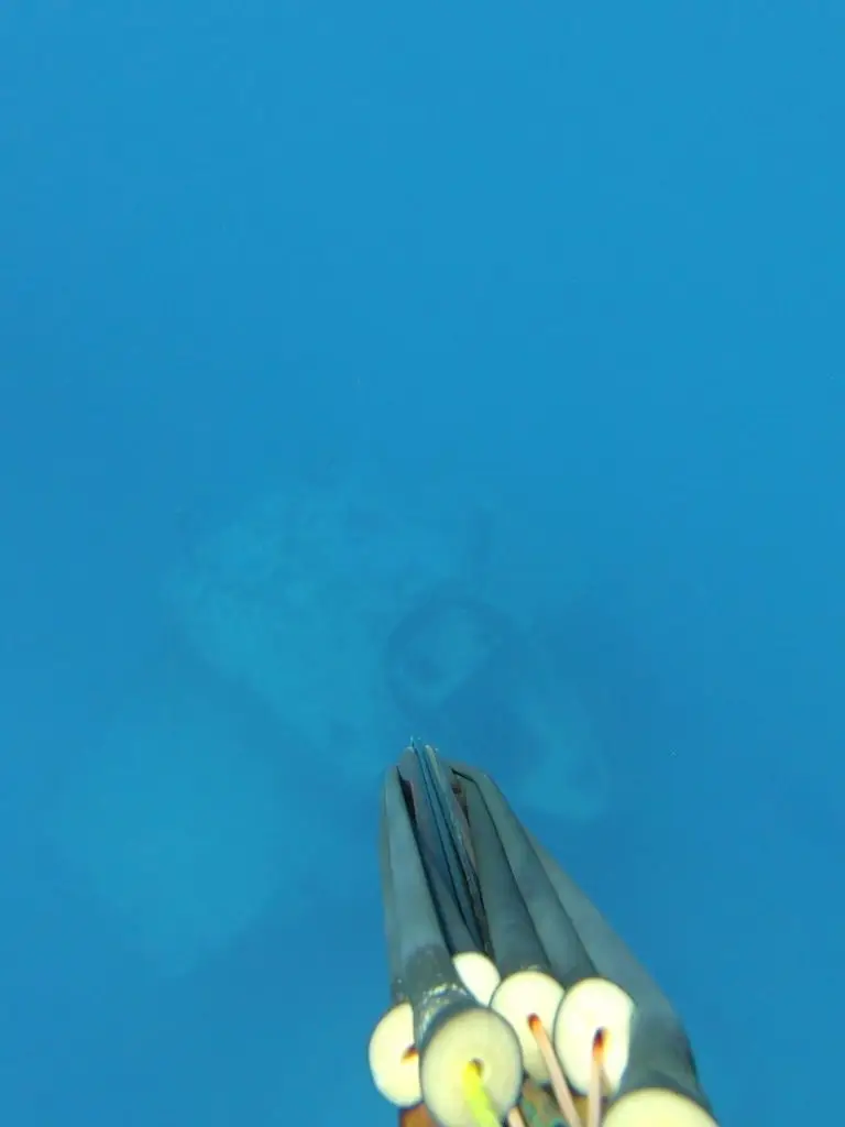 First-person speargun view of underwater wreckage in crystal-clear Lower Keys waters during guided freediving adventure