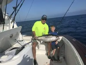 Two charter guests proudly displaying tuna catch aboard main adventure vessel during Lower Keys charter